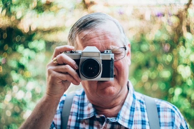 vecchio uomo pantaloni a vita bassa con una vecchia macchina fotografica d&#39;epoca