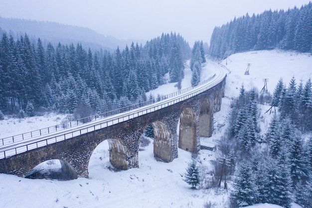 Vecchio viadotto nevoso. vecchio ponte ferroviario coperto di neve in Ucraina