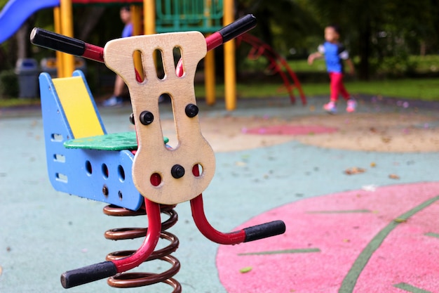 Vedi vide il giocattolo nel parco giochi pubblico nel parco su sfocatura dello sfondo del parco giochi