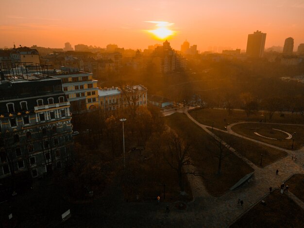 Veduta aerea dal drone sui tetti di case ed edifici al tramonto in città