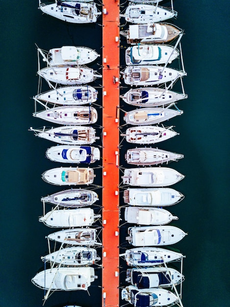 Veduta aerea del porto turistico con barche e yacht in Italia Paesaggio del mare blu con yacht bianchi dall'alto