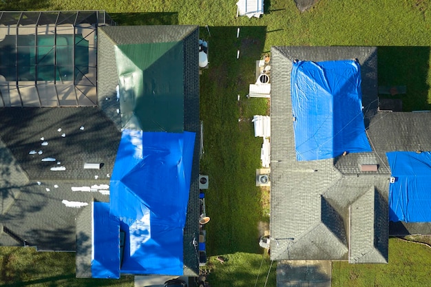Veduta aerea del tetto di una casa danneggiata dall'uragano Ian coperto da un telone protettivo blu contro le perdite d'acqua piovana fino alla sostituzione delle lastre di asfalto