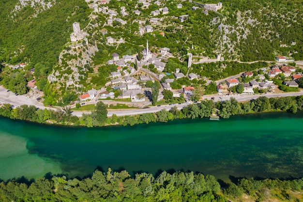 Veduta aerea del vecchio castello medievale e dell'acqua color smeraldo del fiume Neretva nella città di Pocitelj in Bosina ed Erzegovina