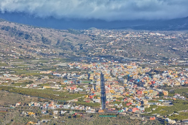 Veduta aerea della bellissima città di Los Llanos La Palma e delle Isole Canarie Una piccola città vivace o un villaggio urbano circondato da lussureggianti piante verdi o natura in un pomeriggio nuvoloso