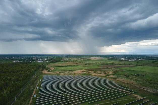 Veduta aerea della centrale solare su campo verde Fattoria elettrica con pannelli per la produzione di energia ecologica pulita