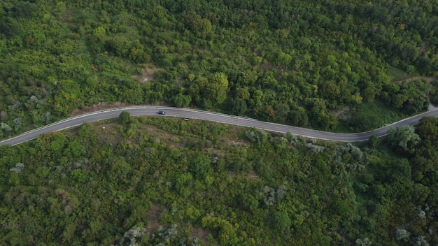 Veduta aerea della foresta con una strada che attraversa con l'auto