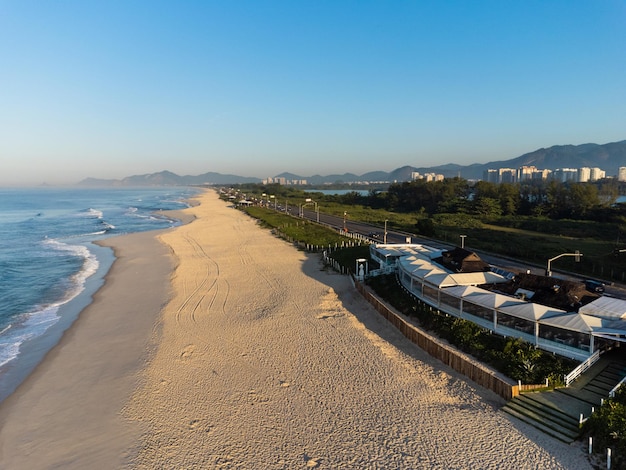 Veduta aerea della spiaggia di Reserva Laguna Marapendi e traffico automobilistico su Lucio Costa avenue Barra da Tijuca e Recreio a Rio de Janeiro in Brasile Alba Giornata di sole Foto del drone Praia da Reserva