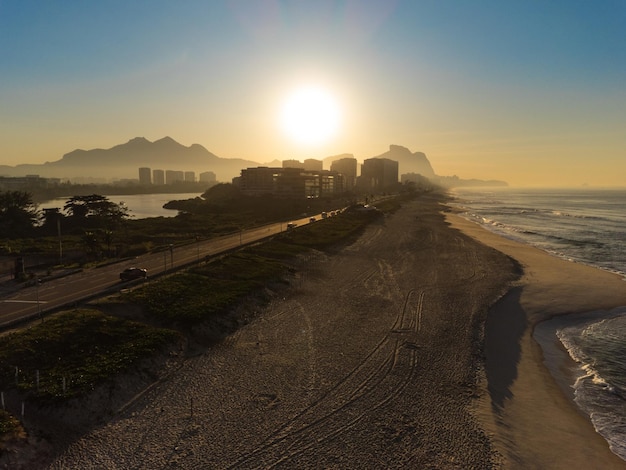 Veduta aerea della spiaggia di Reserva Laguna Marapendi e traffico automobilistico su Lucio Costa avenue Barra da Tijuca e Recreio a Rio de Janeiro in Brasile Alba Giornata di sole Foto del drone Praia da Reserva