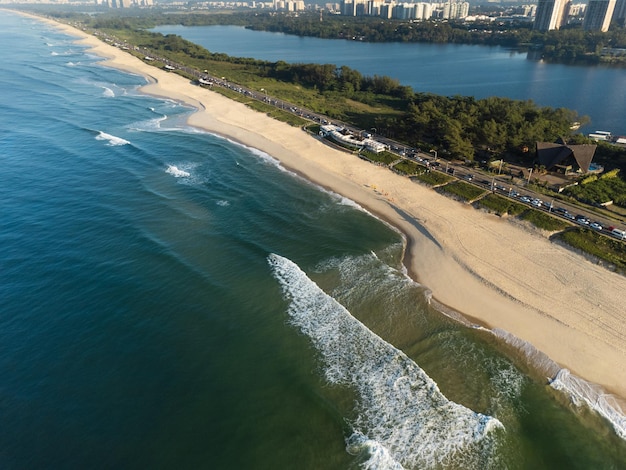 Veduta aerea della spiaggia di Reserva Laguna Marapendi e traffico automobilistico su Lucio Costa avenue Barra da Tijuca e Recreio a Rio de Janeiro in Brasile Alba Giornata di sole Foto del drone Praia da Reserva