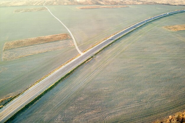 Veduta aerea della strada interurbana con auto a guida veloce al tramonto Vista dall'alto dal drone del traffico autostradale in serata