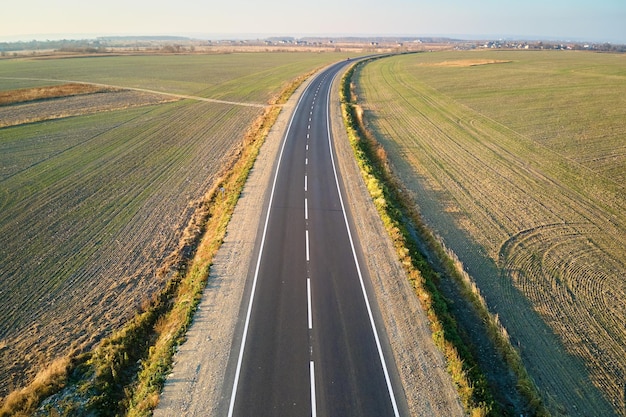 Veduta aerea della strada interurbana vuota al tramonto. Vista dall'alto dal drone dell'autostrada in serata