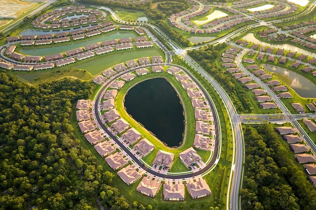 Veduta aerea di case stipate in Florida chiuse club abitativi con acqua del lago al centro Case familiari come esempio di sviluppo immobiliare nei sobborghi americani