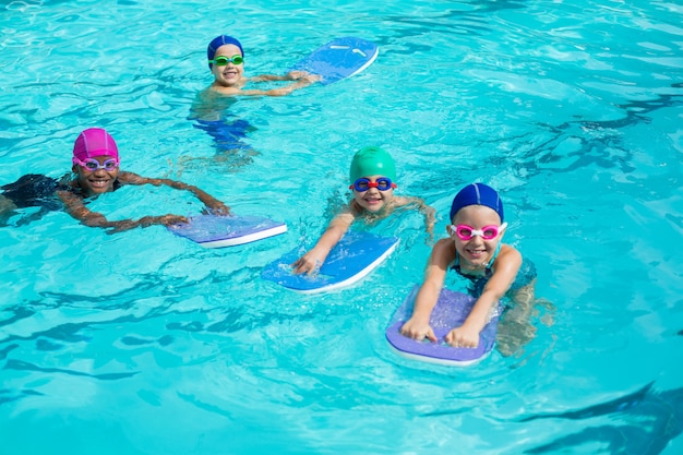 Veduta dall'alto di piccoli nuotatori con kickboard godendo in piscina