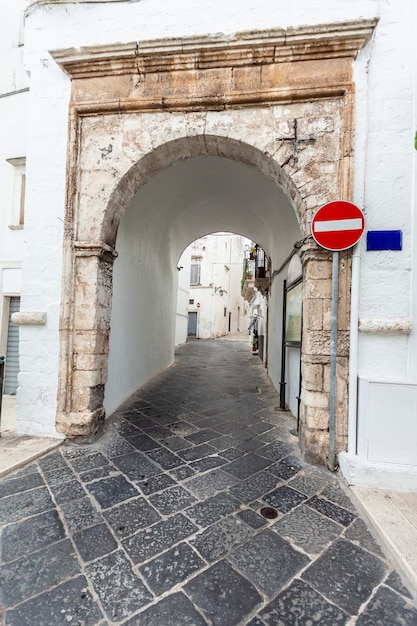Veduta delle strade vuote del centro storico di Martina Franca con belle case dipinte di bianco e un segnale di stop. Splendida giornata in una città turistica, Puglia, Italia meridionale.