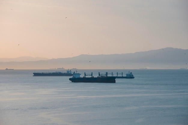 Veduta di navi da carico al tramonto nello Stretto di Gibilterra Foto di alta qualità