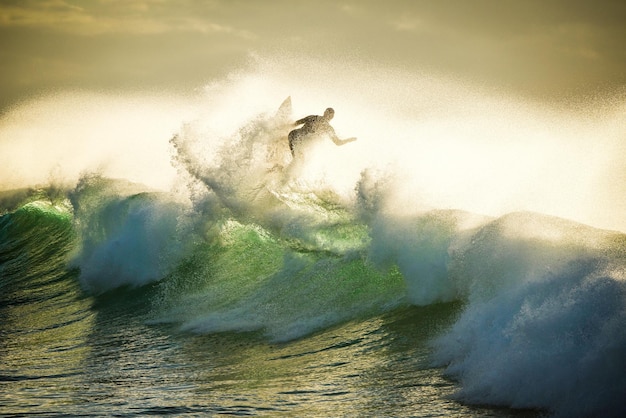 Veduta di un uomo che fa surf sulle onde
