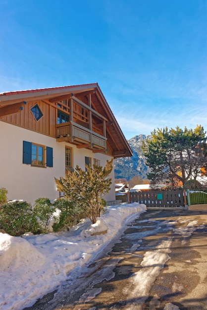 Veduta di una casa a Garmisch-Partenkirchen costruita in tipico stile di montagna in una soleggiata giornata invernale.