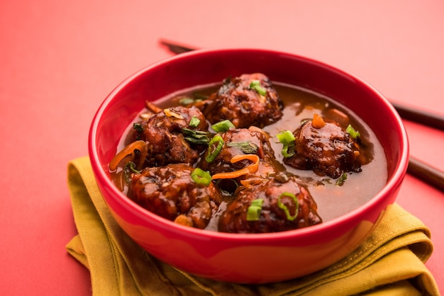 Veg o pollo Manchurian con sugo - Cibo popolare dell'India servito in una ciotola con bacchette