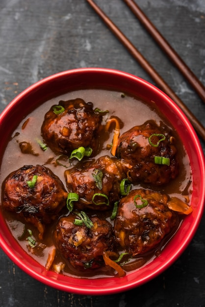 Veg o pollo Manchurian con sugo - Cibo popolare dell'India servito in una ciotola con bacchette