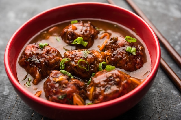 Veg o pollo Manchurian con sugo - Cibo popolare dell'India servito in una ciotola con bacchette