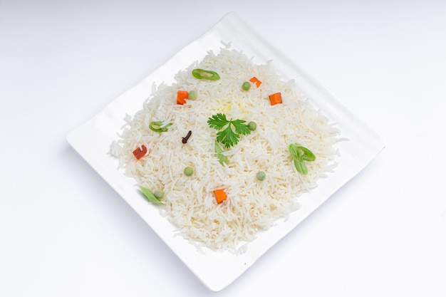 Veg Pulao a base di riso basmati verdure e spezie disposte in stoviglie bianche quadrate