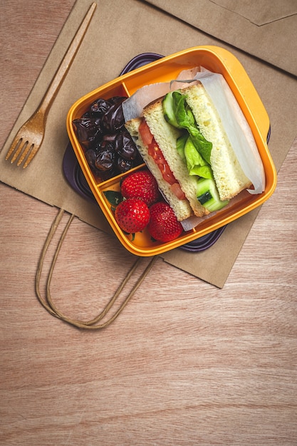 Vegan Sandwich in un contenitore di plastica sul tavolo di legno. Concetto di cibo sano