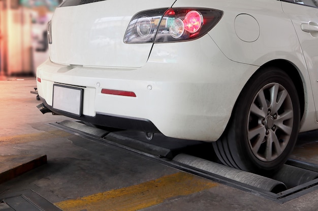 Veicolo con tester per freni a rulli, auto di colore bianco.