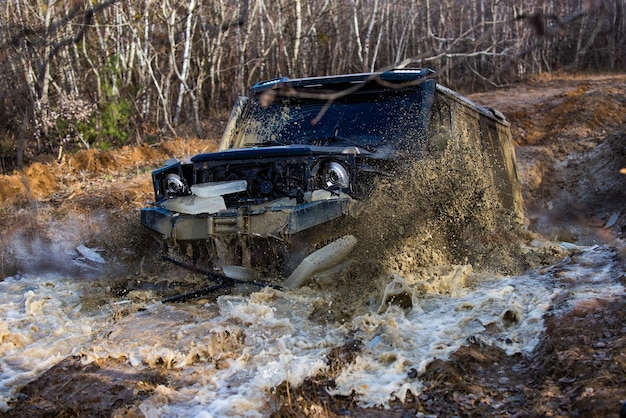 Veicolo fuoristrada che esce da un concetto di intrattenimento estremo fango fuoristrada in azione rally racin...