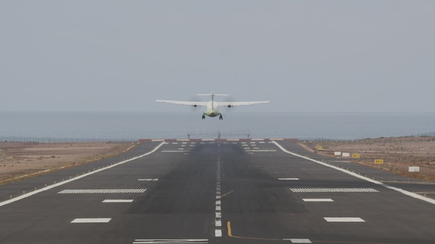 Velivolo in decollo dalla pista dall'oceano