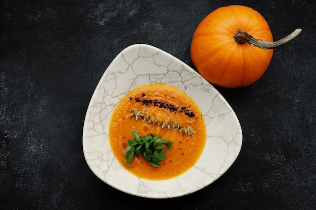 Vellutata di zucca con semi e rucola