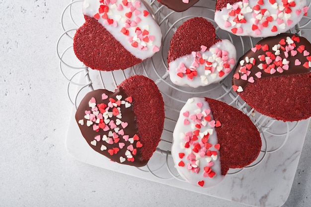 Velluto rosso o biscotti brownie a forma di cuore in glassa di cioccolato su sfondo rosa romantico Idea dessert per San Valentino Festa della mamma o della donna Gustoso dolce fatto in casa Torta per San Valentino