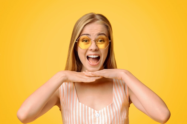 Vende pazze ragazzine gioiose con gli occhiali da sole che poggiano il mento sulle mani e urlano posando sopra il giallo