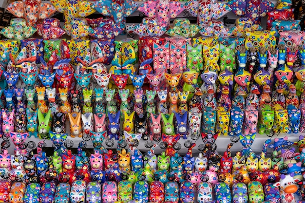 Vendita di souvenir - divertenti animali in legno fatti a mano nel mercato di strada. Giocattoli per bambini colorati luminosi e decorazioni per interni. Ubud, isola di Bali, Indonesia. Avvicinamento