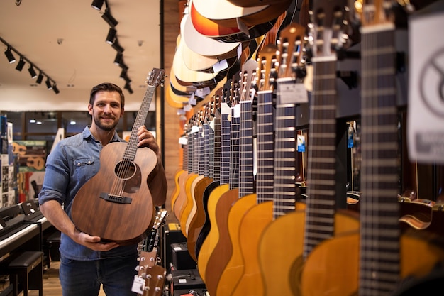 Venditore di chitarra che mostra il nuovo modello di chitarra nel negozio di musica.