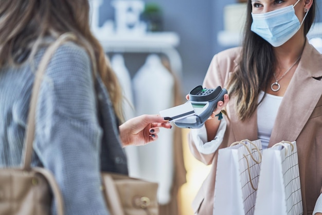 Venditore e compratore della donna nel negozio di vestiti Foto di alta qualità