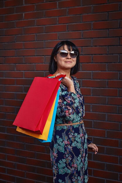 Venerdì nero. Donna che mantiene i sacchetti di carta in mano. Centro commerciale.