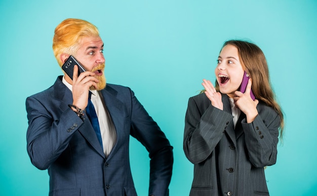 Vera felicità. uomo d'affari parlare al telefono con una piccola ragazza. il papà barbuto si è tinto i capelli. giacca oversize per bambini. Uomini d'affari che utilizzano dispositivi. Squadra familiare di successo. imprenditoria. discussione d'affari.