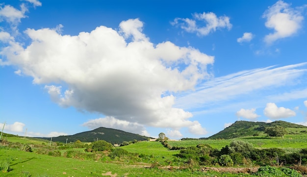 Verdi colline sotto un cielo blu con nuvole in Sardegna Italia