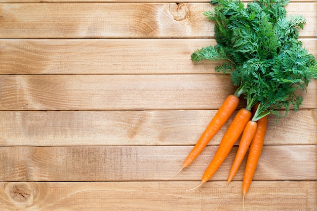 Verdura fresca della carota con i fogli su legno