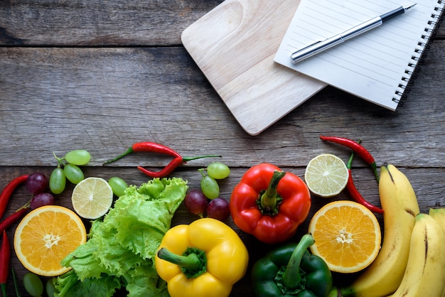 Verdura fresca e frutta per la cena di forma fisica sulla vista superiore del fondo di legno, concetto dell&#39;alimento