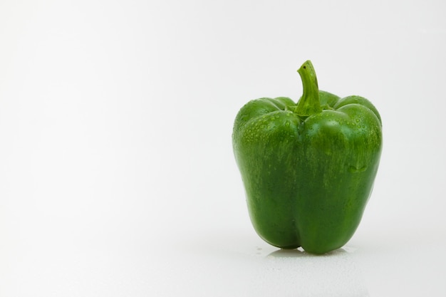 Verdura isolata del peperone verde su bianco.