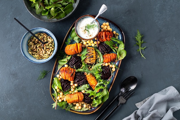 Verdure a radice arrostite fino a renderle morbide al centro e croccanti con semi di zucca di ceci e foglie di lattuga fresca Insalata fresca sana