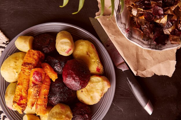 Verdure al forno sbucciate patate al forno carote barbabietole su fondo rustico Tutta la dieta alimentare Dieta mediterranea