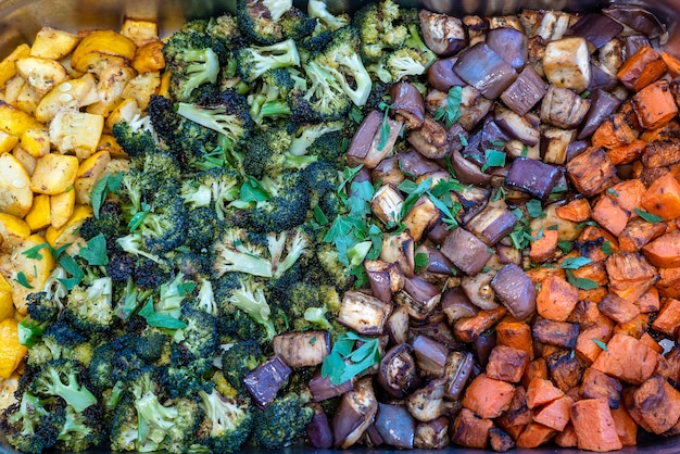 Verdure al vapore broccoli zucchine melanzane e carote in un primo piano di una padella di metallo