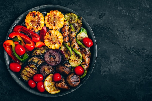 Verdure alla griglia in una ciotola sullo sfondo di pietra scura