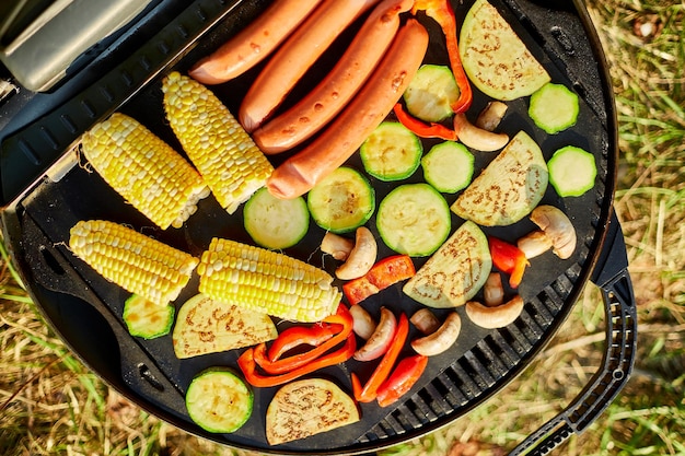 Verdure arrosto e salsicce vegane sul barbecue grill a gas all'aperto nel cortile Verdure alla griglia estate picnic in famiglia cibo sulla natura