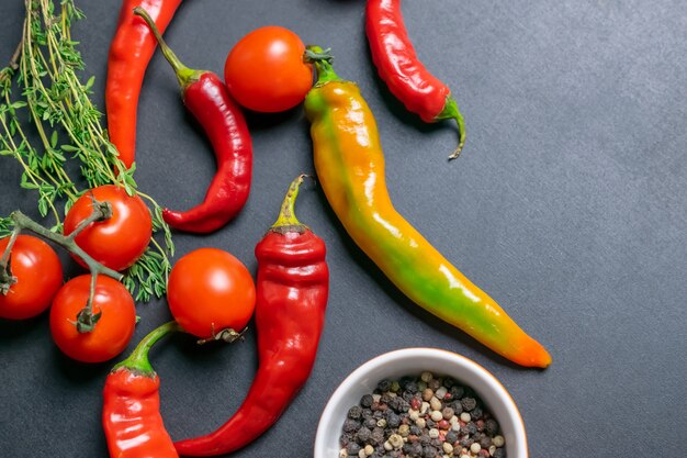 Verdure biologiche dell'azienda agricola su un bordo dell'ardesia, ingredienti per salsa o insalata.