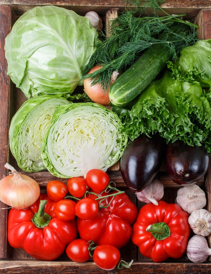 Foto verdure biologiche fresche in cassa di legno - cavoli, pomodori, peperoni, melanzane,
