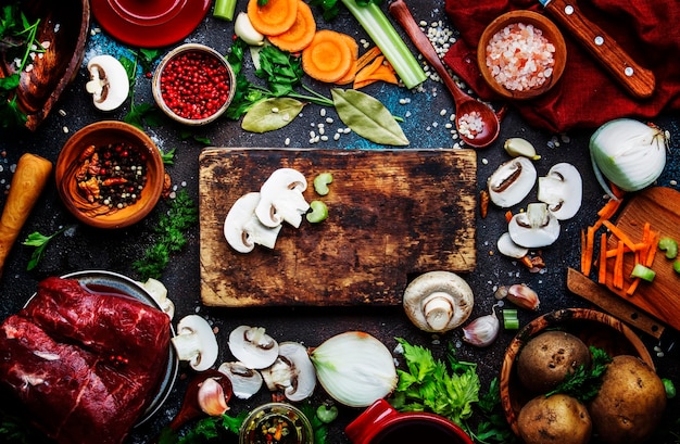 Verdure biologiche fresche ingredienti spezie e carne per zuppa o brodo sul tavolo da cucina vintage...