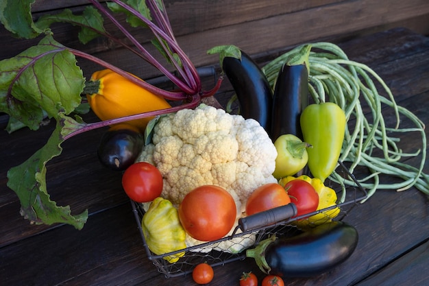 Verdure di fattoria biologiche su un tavolo di legno scuro cavolfiore fresco crudo fagioli verdi zucchine barbabietole di mais Copia spazio